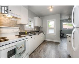 A kitchen with white cabinets and a white stove top oven.