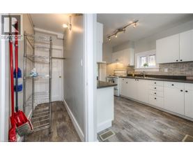 A white kitchen with a red broom in the foreground.