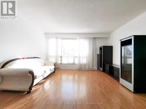 A living room with a white sofa and a black television set.