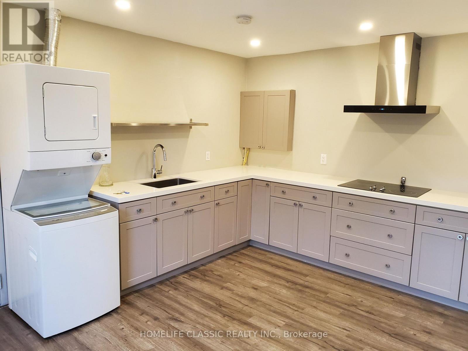 A white kitchen with wooden floors and a white dishwasher.