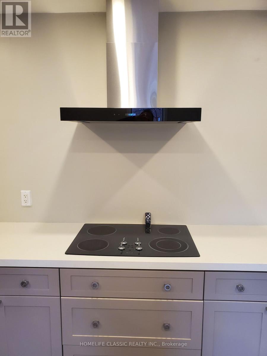 A modern kitchen with a black stove top and white countertop.
