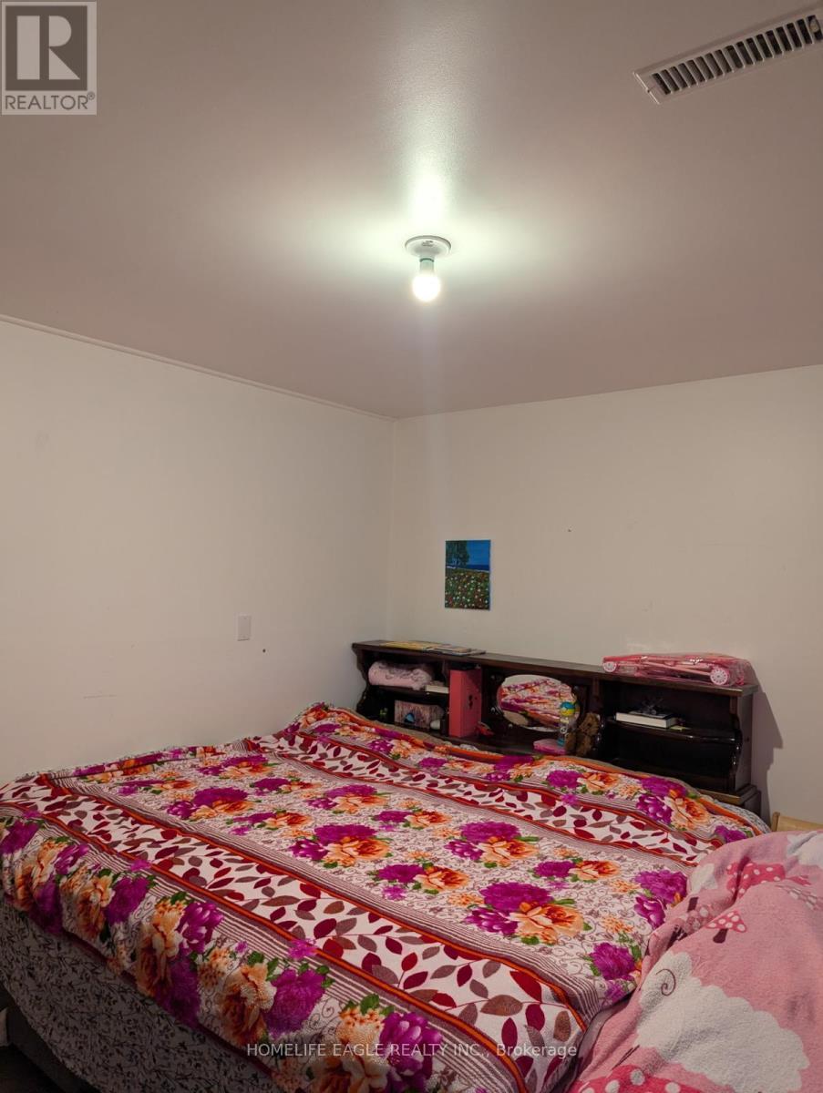 A bedroom with a bed covered in a floral print bedspread.