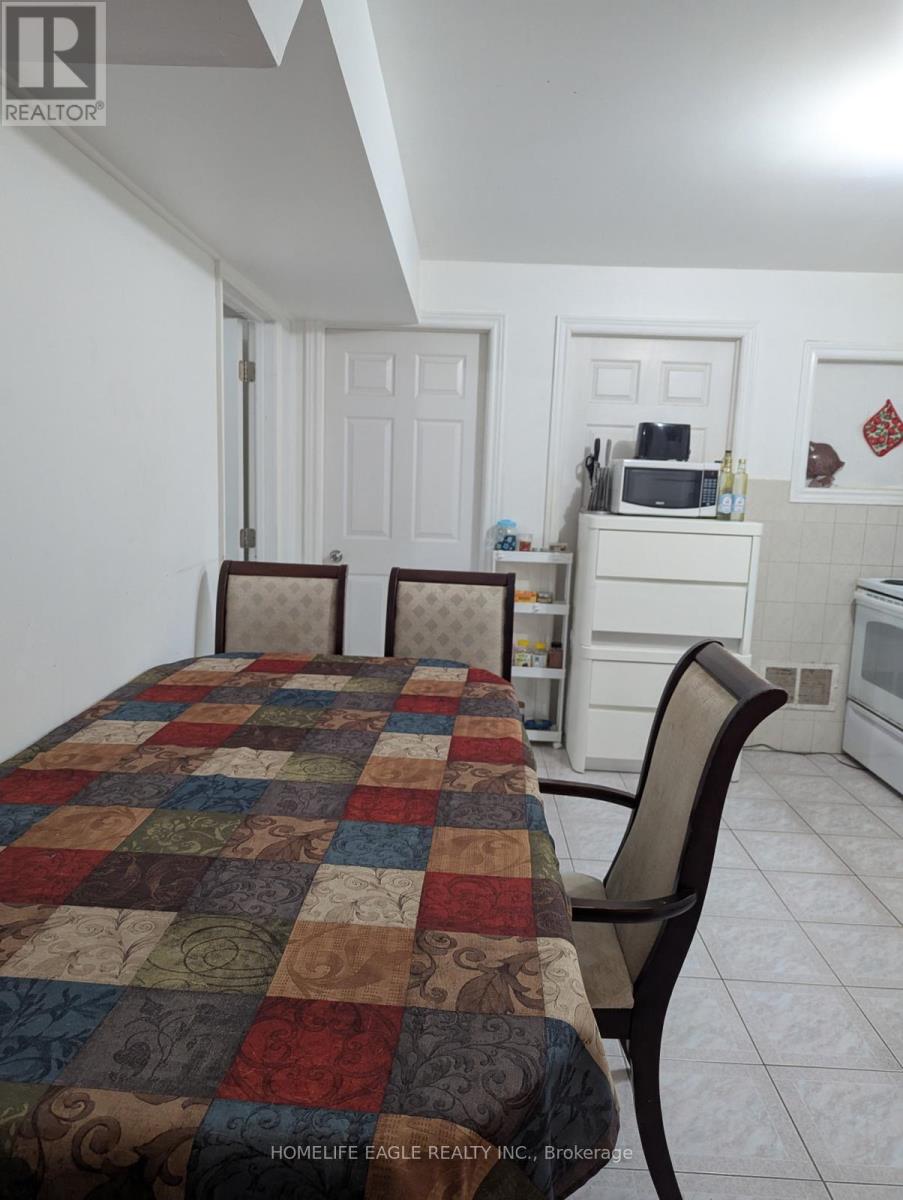 A kitchen with a table and chairs in front of it.