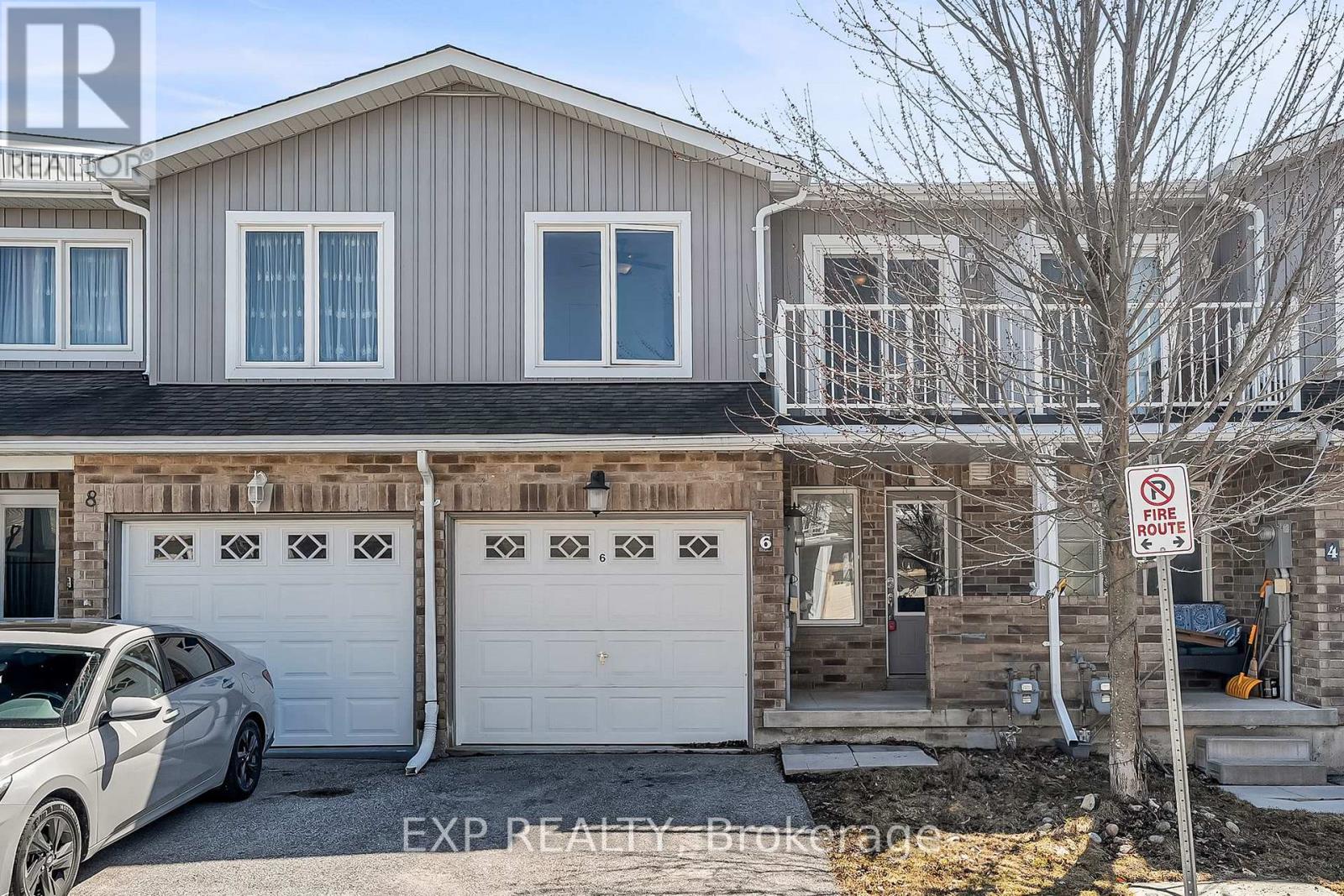 A two-story house with a garage and a car parked in front.