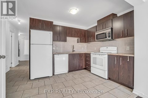 A kitchen with white appliances and brown cabinets.