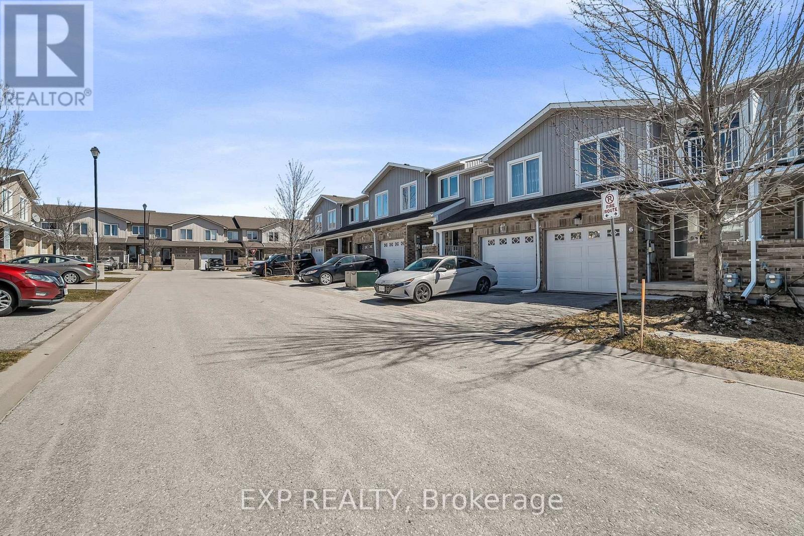 A street view of a residential area with houses and parked cars.