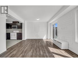 A spacious room with wooden flooring and white walls.