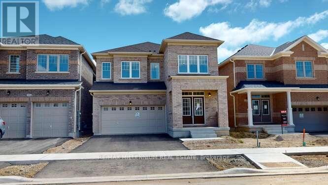 A real estate sign is displayed in front of a row of houses.