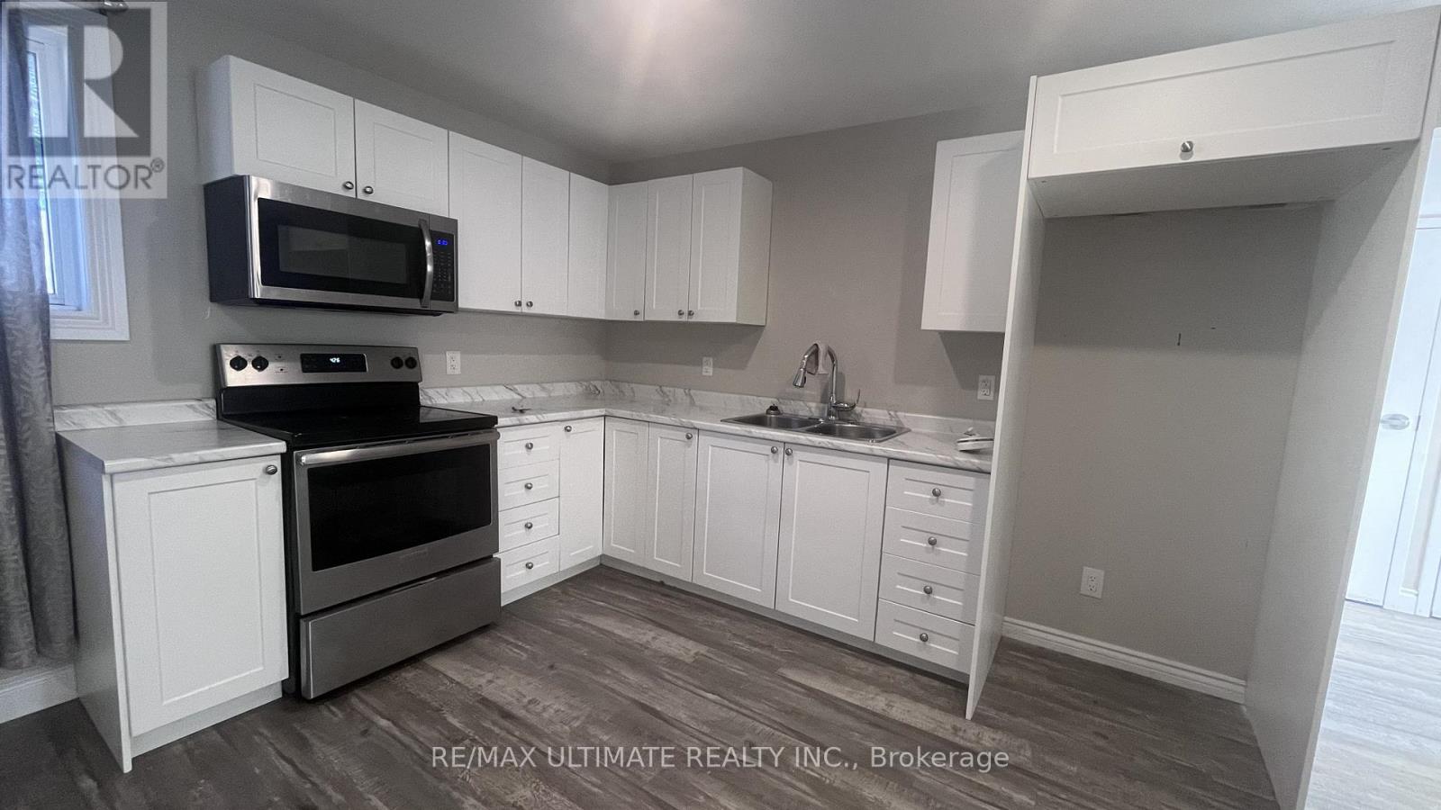 A kitchen with white cabinets and a microwave above the stove.