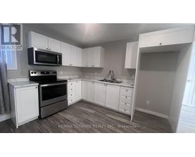 A kitchen with white cabinets and a microwave above the stove.