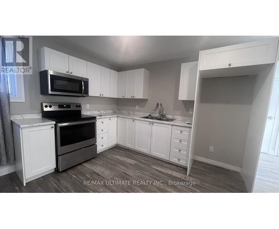 A kitchen with white cabinets and a microwave above the stove.