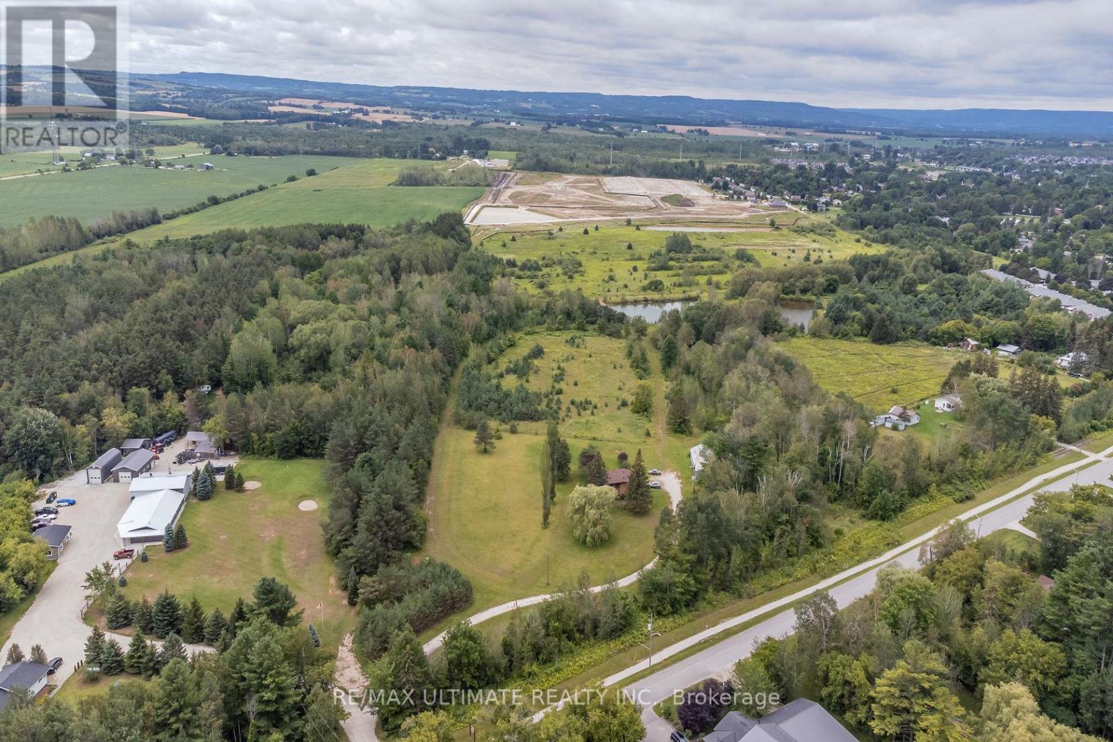 A bird's eye view of a property with a large open field and a building complex.