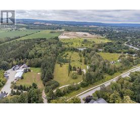 A bird's eye view of a property with a large open field and a building complex.