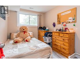 A bedroom with a bed, a dresser, and a window.