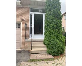 A white door with a black handle is on a brick house.