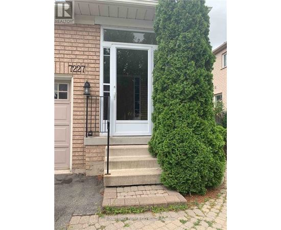 A white door with a black handle is on a brick house.