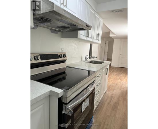 A kitchen with white cabinets and a black stove top.