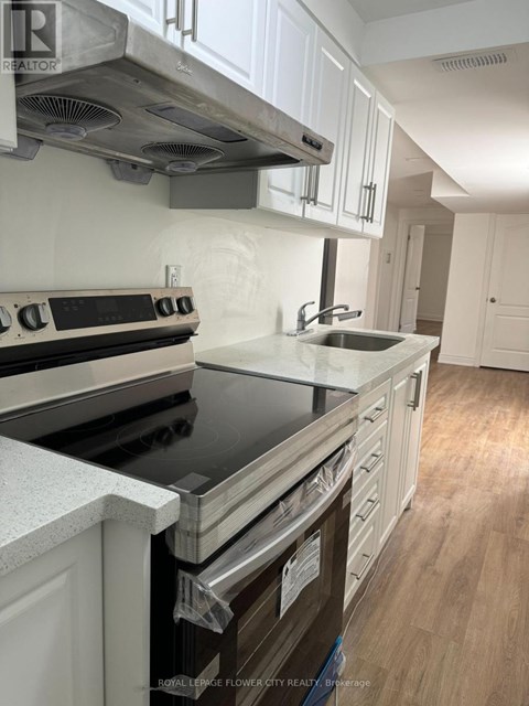A kitchen with white cabinets and a black stove top.