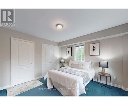 A bedroom with a bed, two lamps, and a window.