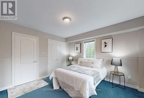 A bedroom with a bed, two lamps, and a window.