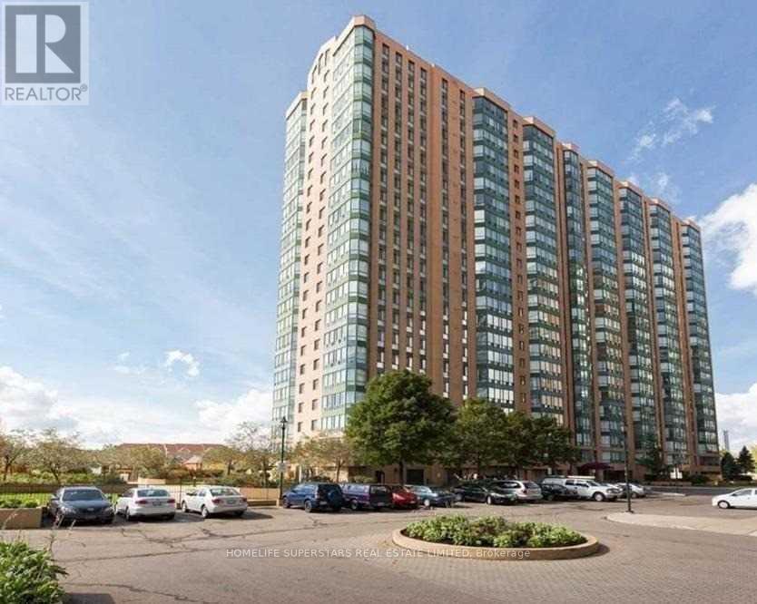 A tall building with a parking lot in front of it.