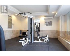 A home gym with a weight machine, bench, and mirror.