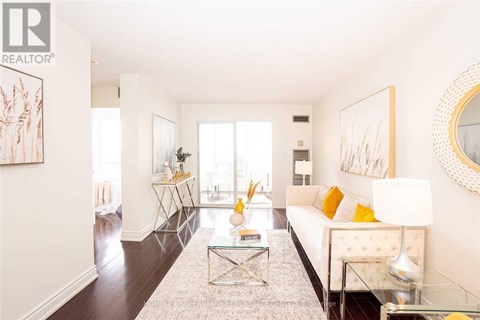 A living room with a white couch and a glass coffee table.