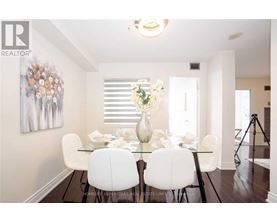 A dining room with a glass table and white chairs.