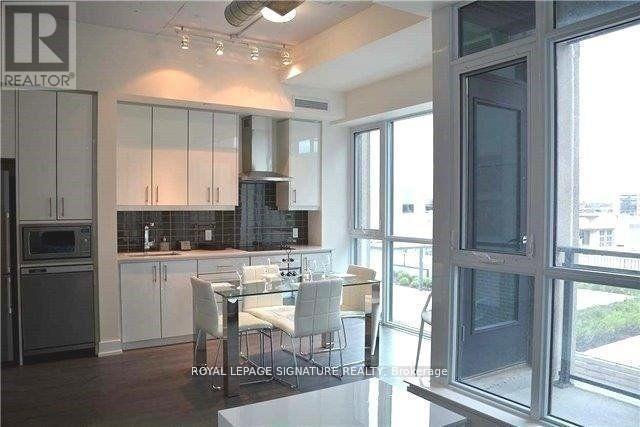 A kitchen with white cabinets and a dining table.