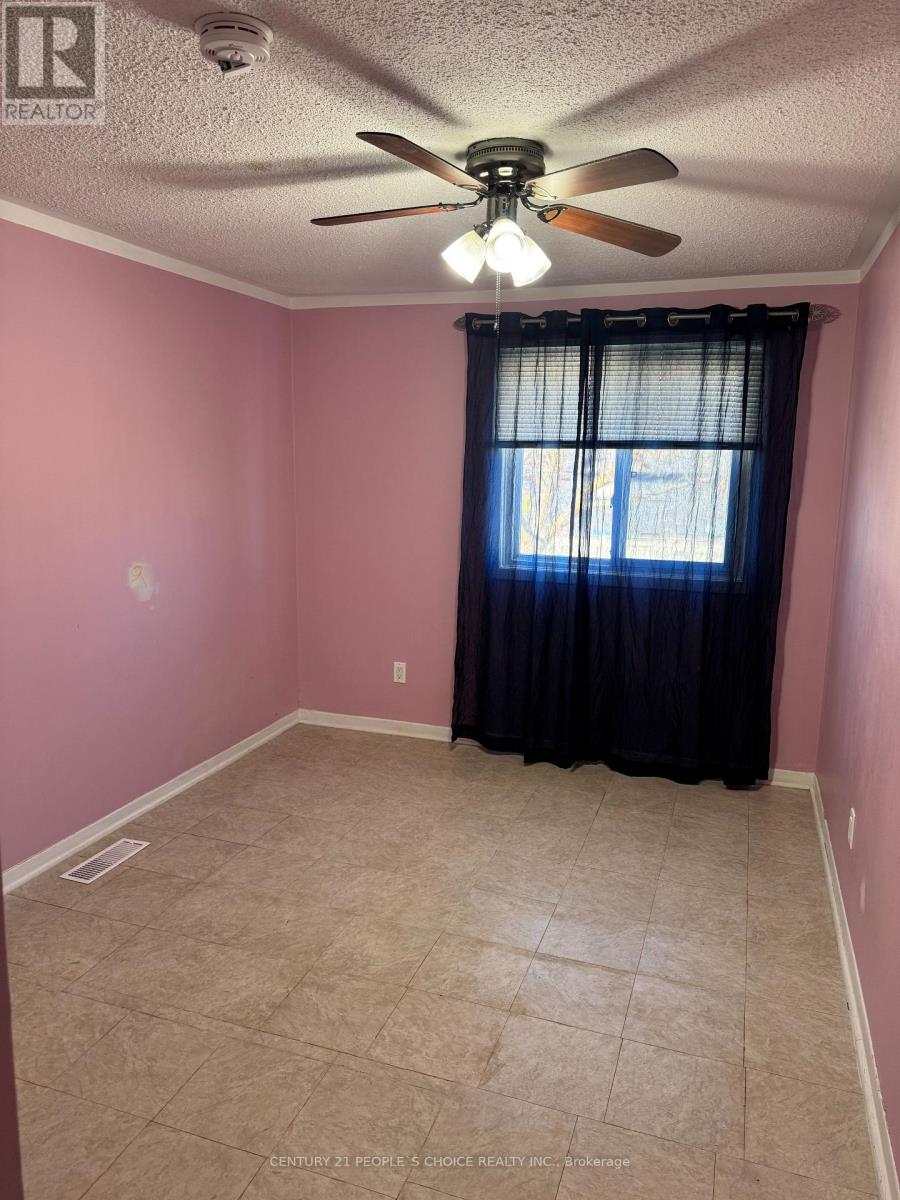 A room with pink walls and a ceiling fan.