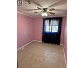 A room with pink walls and a ceiling fan.