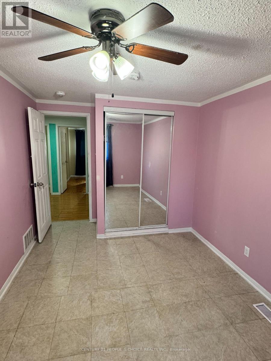 A room with pink walls and a ceiling fan.