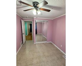 A room with pink walls and a ceiling fan.