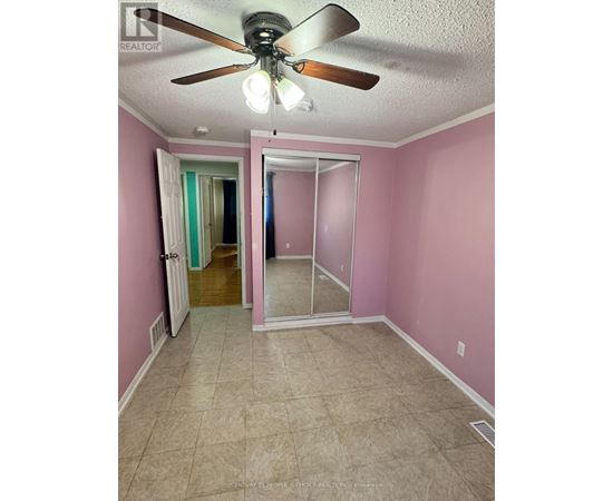 A room with pink walls and a ceiling fan.