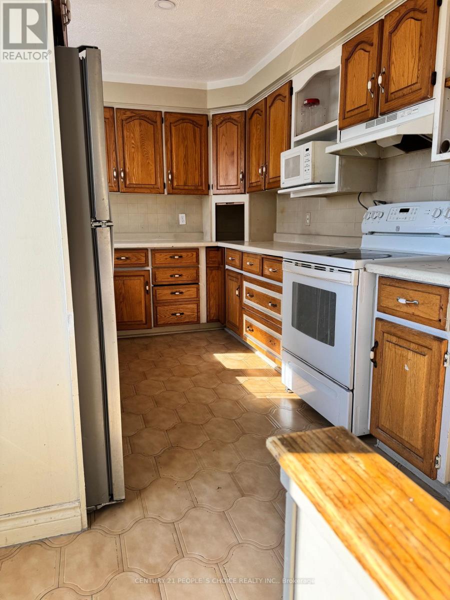 A kitchen with wooden cabinets and a white refrigerator.