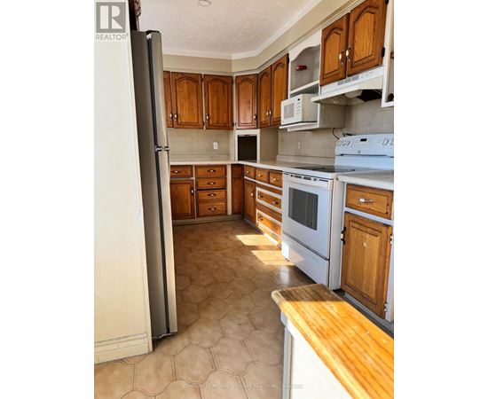A kitchen with wooden cabinets and a white refrigerator.
