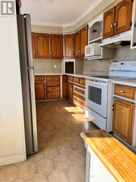 A kitchen with wooden cabinets and a white refrigerator.
