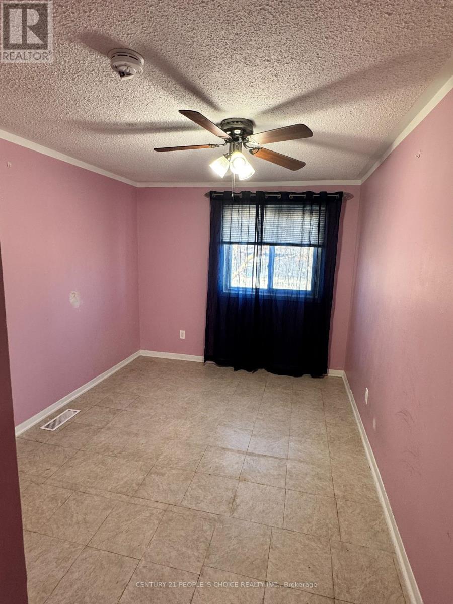 A room with pink walls and a ceiling fan.