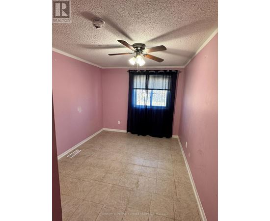 A room with pink walls and a ceiling fan.