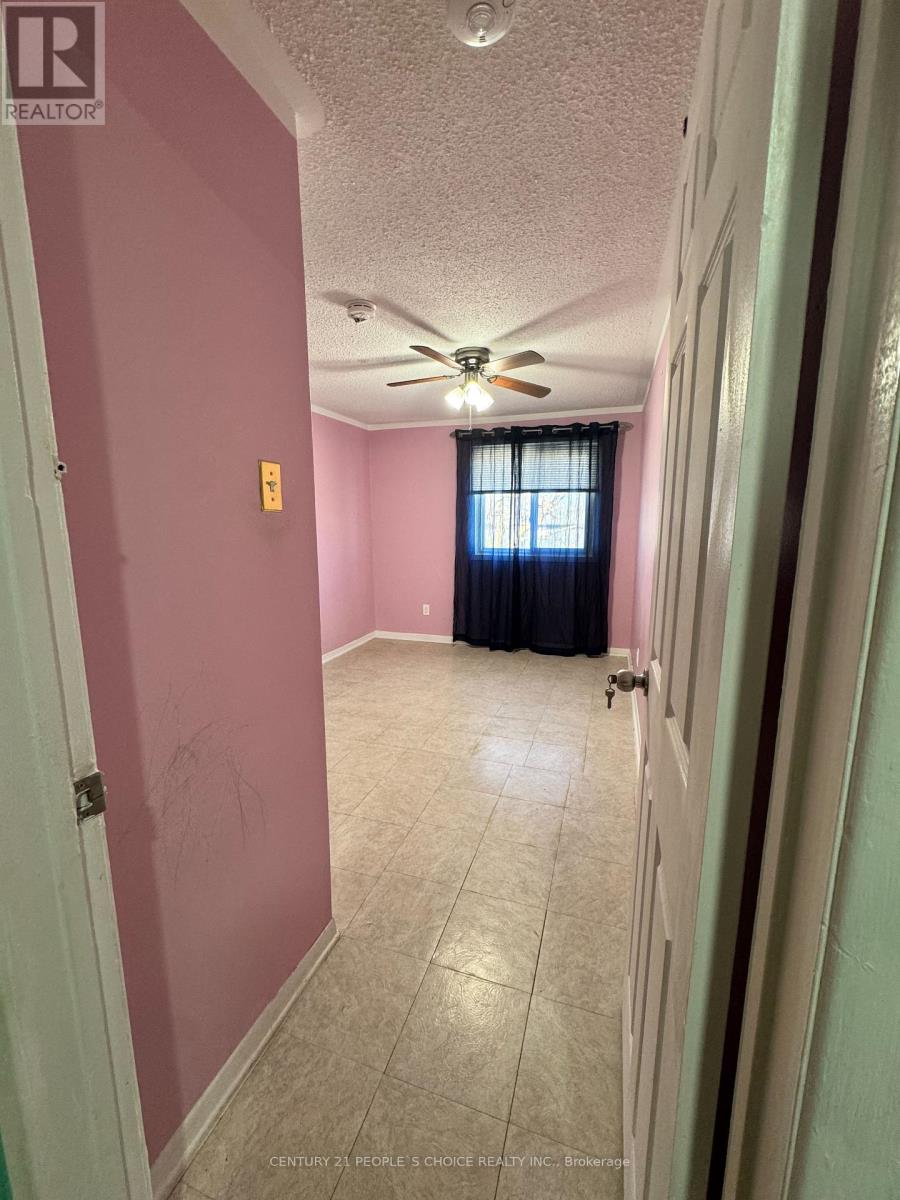 A room with a ceiling fan and a door leading to another room.