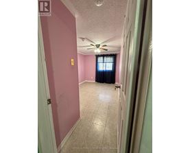 A room with a ceiling fan and a door leading to another room.