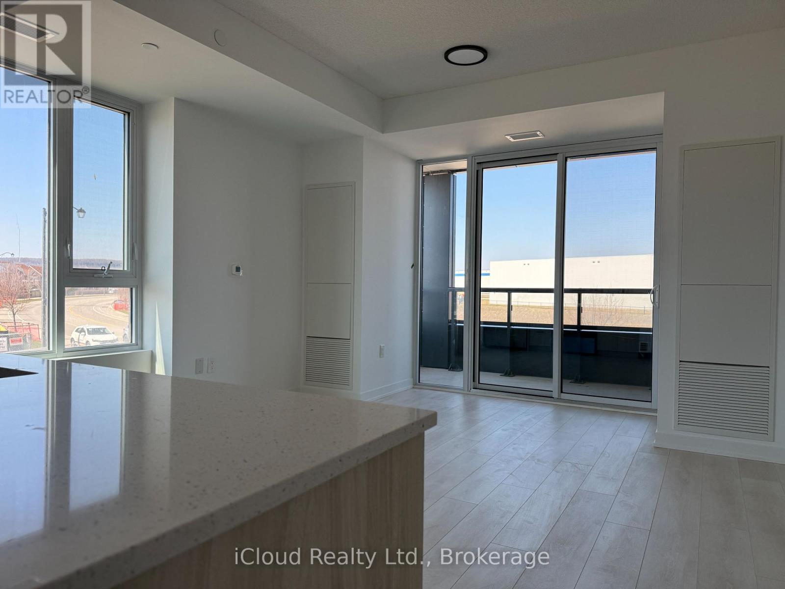A spacious room with a large window and sliding glass doors.