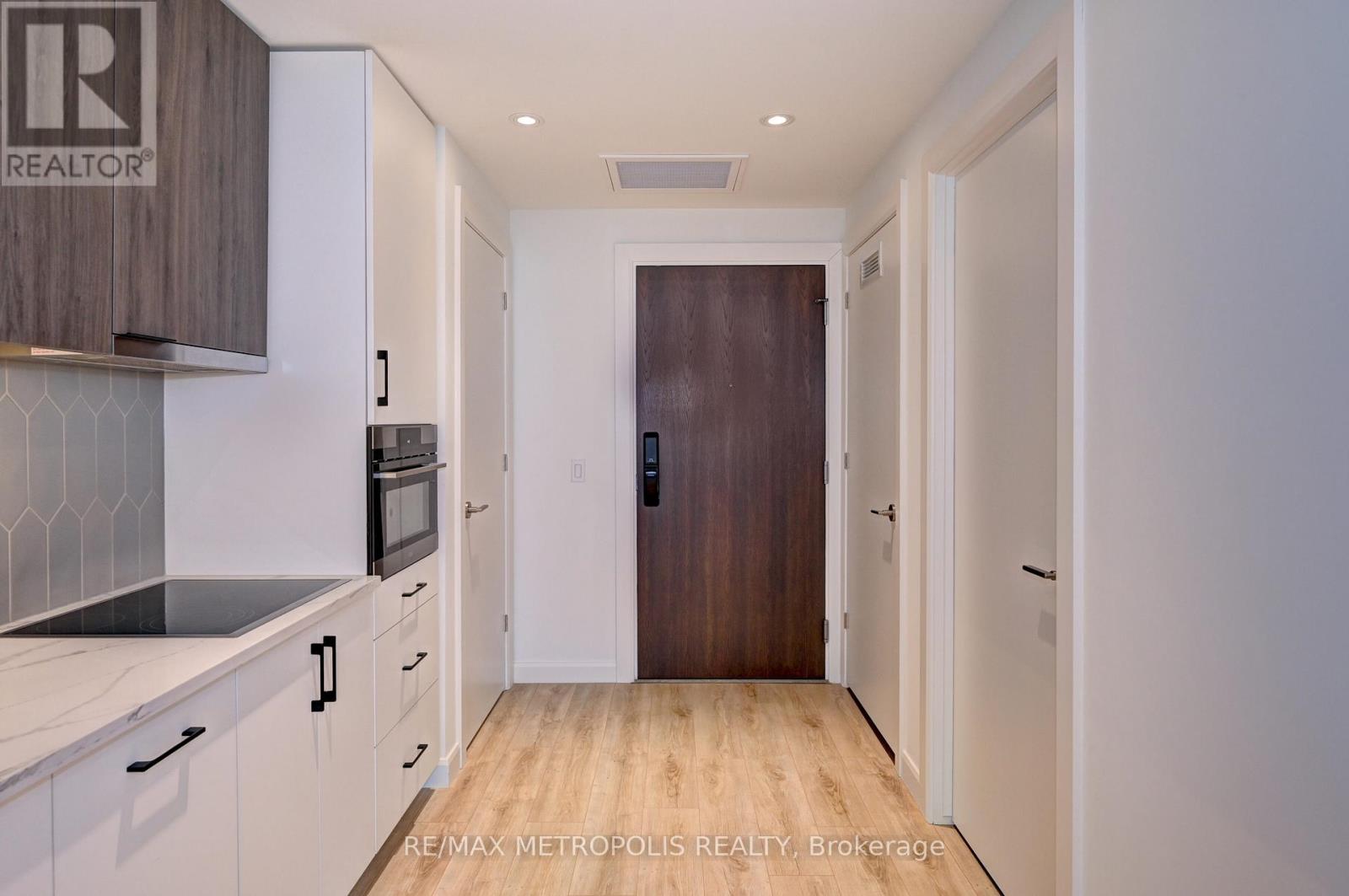 A kitchen with white cabinets and a wooden floor.