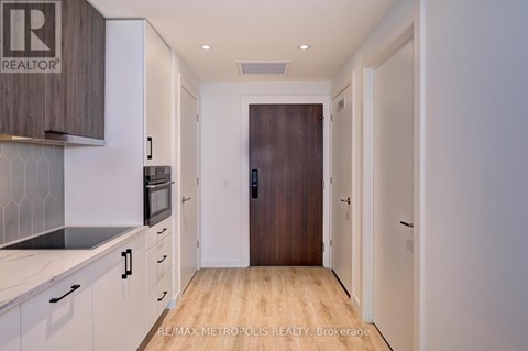 A kitchen with white cabinets and a wooden floor.