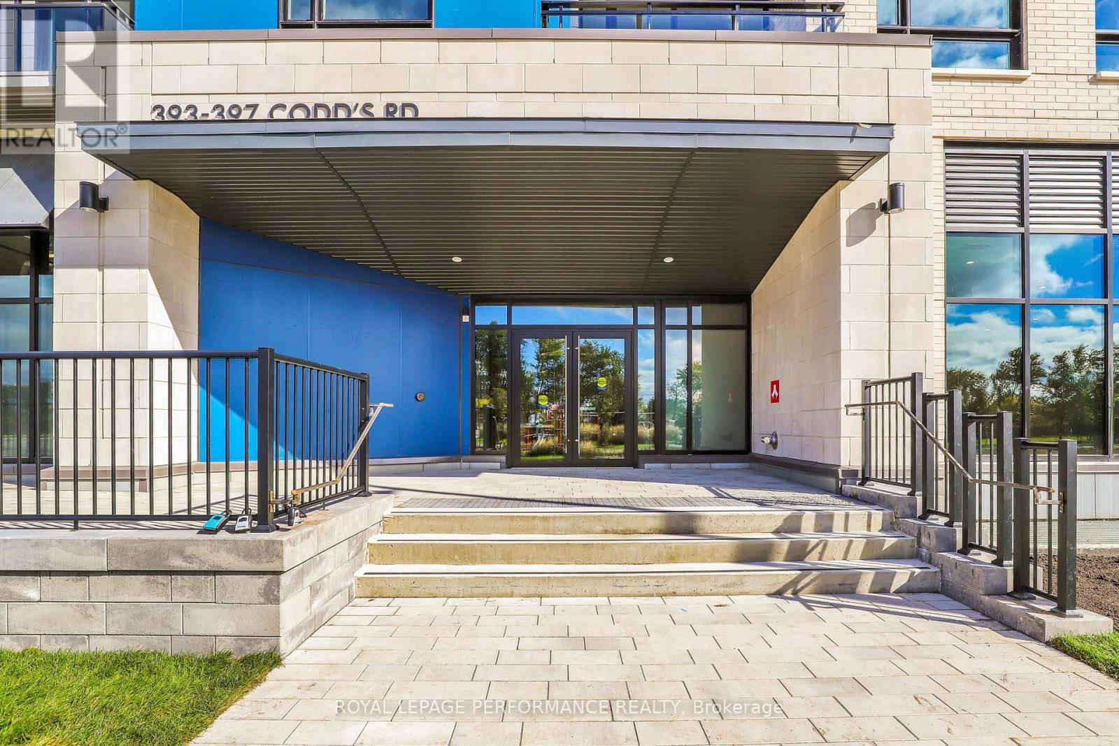 A modern building with a blue wall and a glass door entrance.
