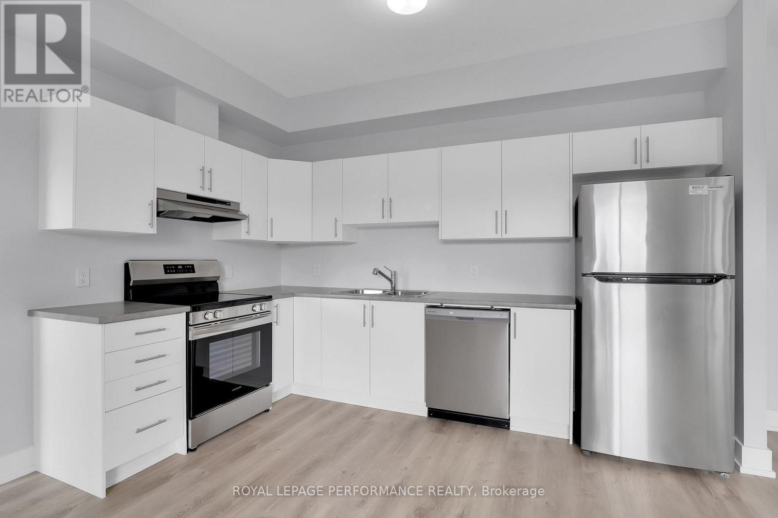 A modern kitchen with white cabinets and stainless steel appliances.