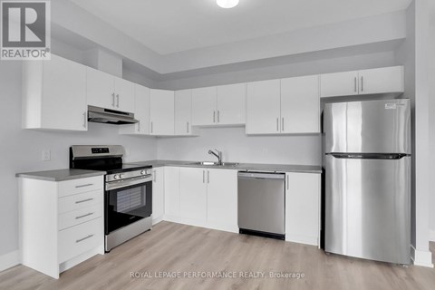 A modern kitchen with white cabinets and stainless steel appliances.