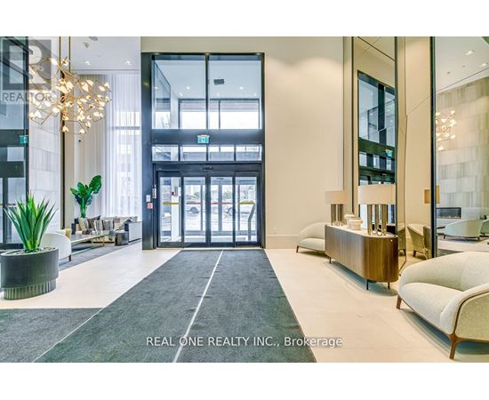 A reception area with a large glass door and a plant in a pot.