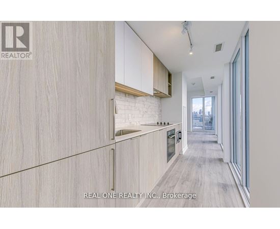 A modern kitchen with wooden cabinets and a white brick accent wall.