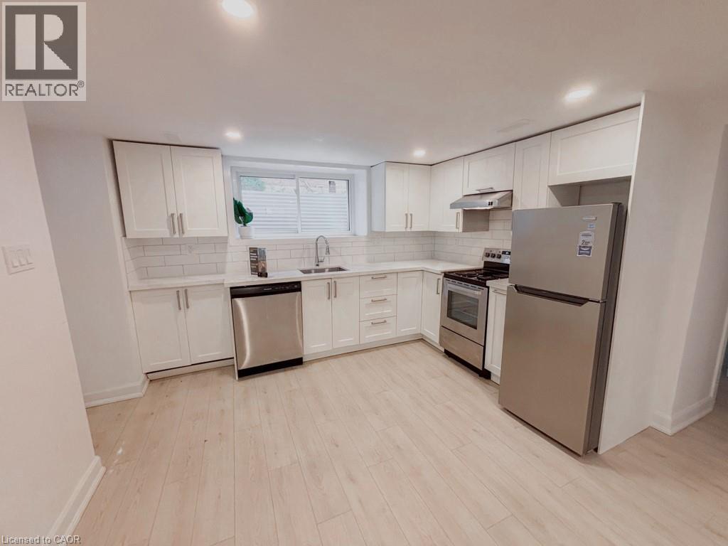 A kitchen with white cabinets and a refrigerator.